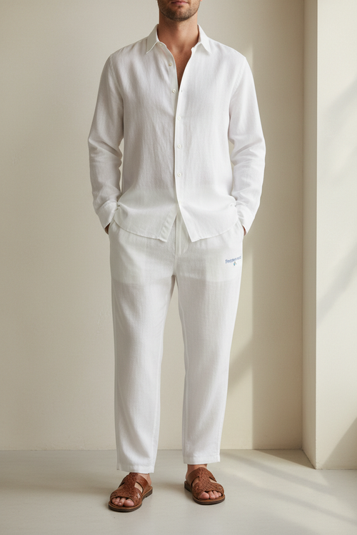 Man in White linen pants with Logo "Freshwater Co." wearing a white linen shirt and brown sandals. make image height 1248px and width 832px